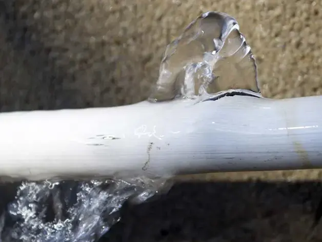 Water spraying from a burst supply pipe in a Sandy, UT home