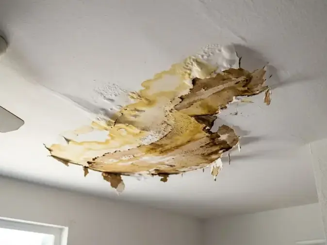 Water-damaged ceiling drywall peeling and stained from a leak above in Sandy, UT